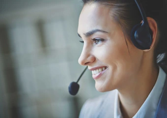 Eine Frau mit Headset berät ihren Kunden telefonisch.
